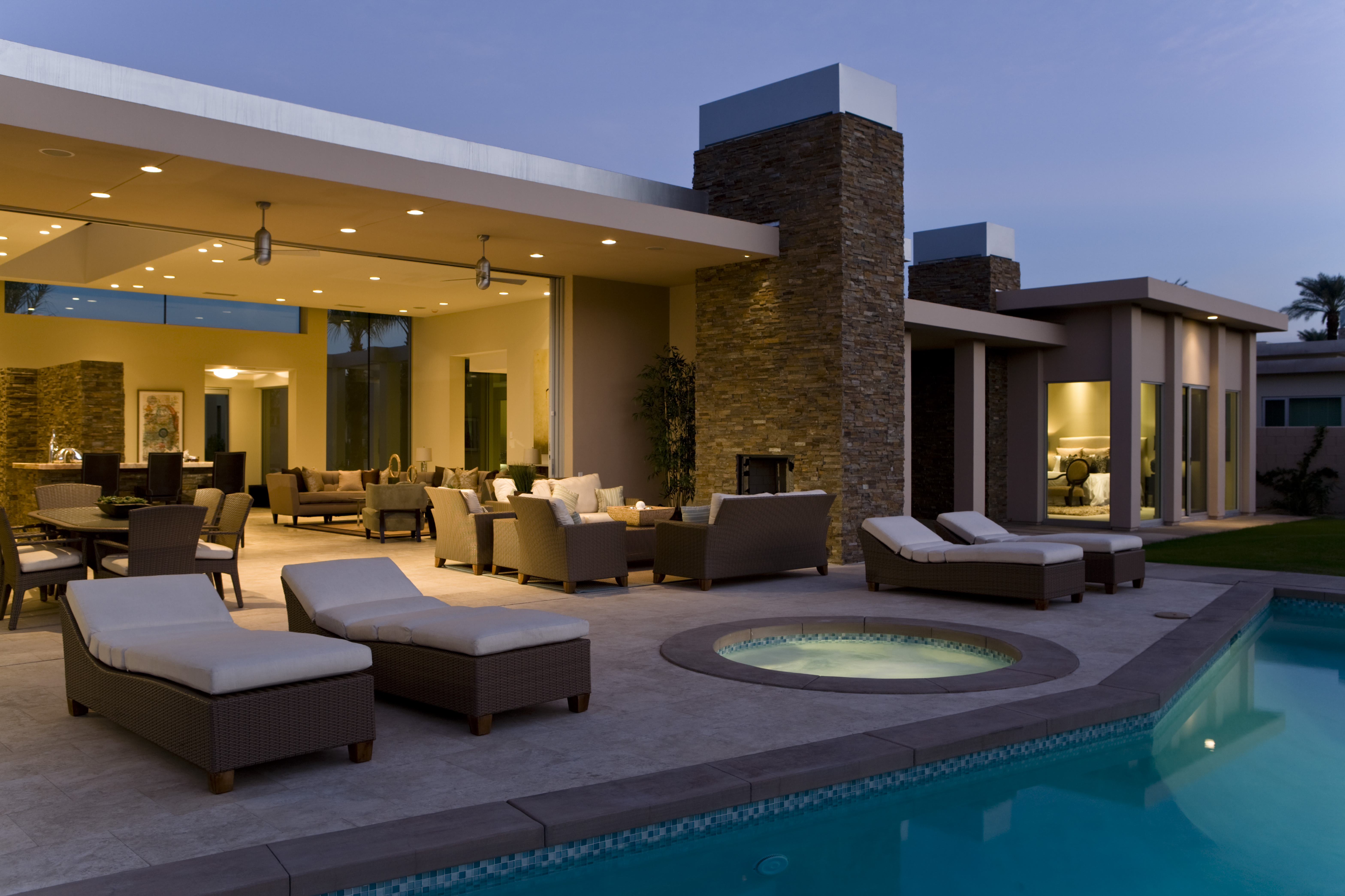 Luxury custom home exterior with pool at night showcasing premium outdoor living space
